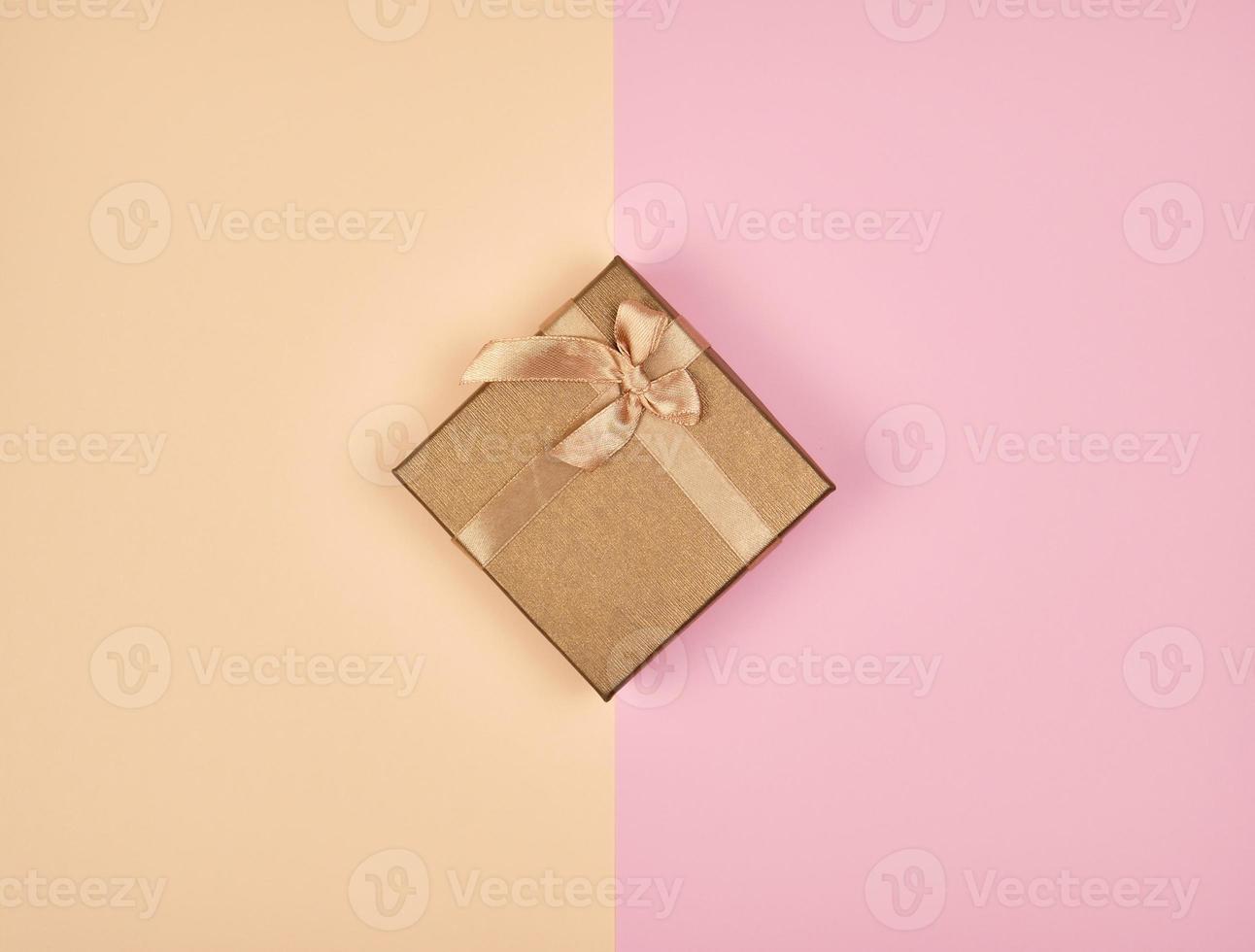 closed square box with a bow on an abstract colored background photo