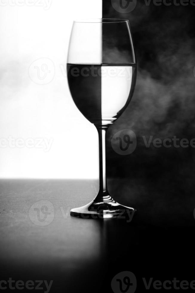 a glass of water and smoke on a black and white background photo
