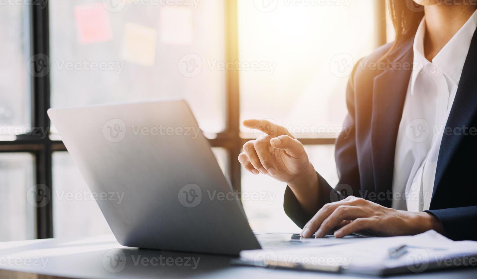 Asian Business woman using calculator and laptop for doing math finance on an office desk, tax, report, accounting, statistics, and analytical research concept photo