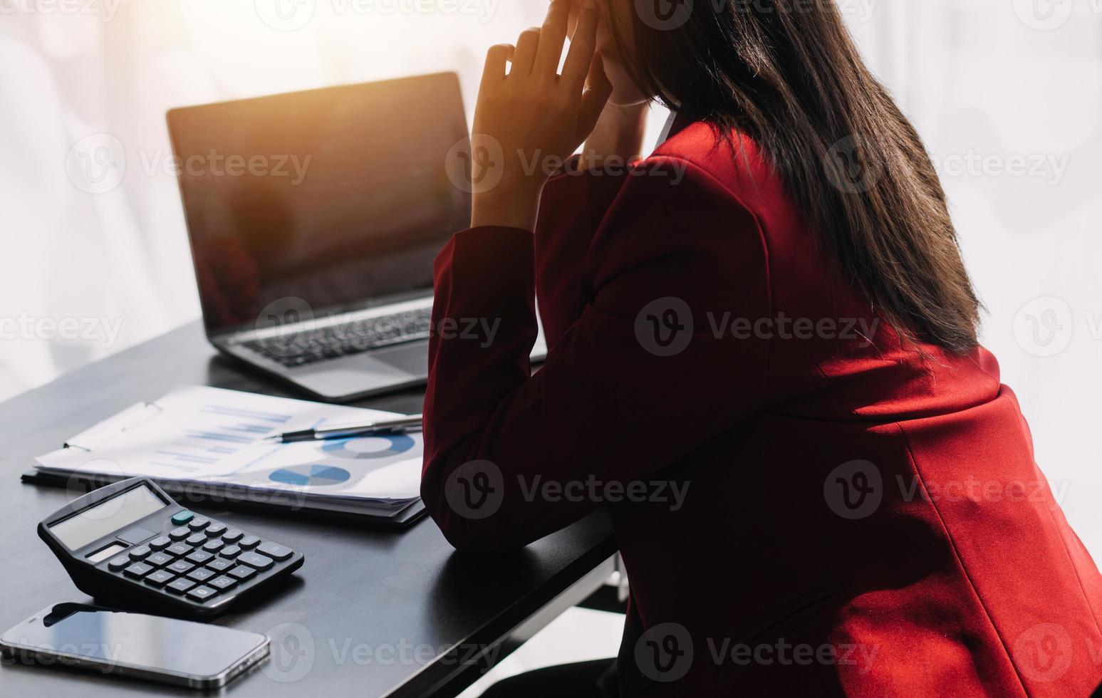 Asian Business woman using calculator and laptop for doing math finance on an office desk, tax, report, accounting, statistics, and analytical research concept photo