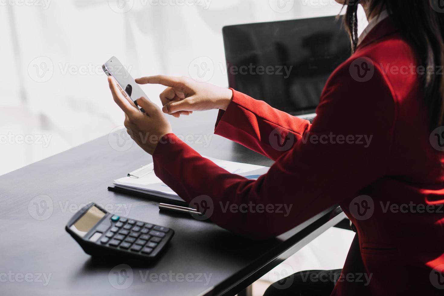 Asian Business woman using calculator and laptop for doing math finance on an office desk, tax, report, accounting, statistics, and analytical research concept photo