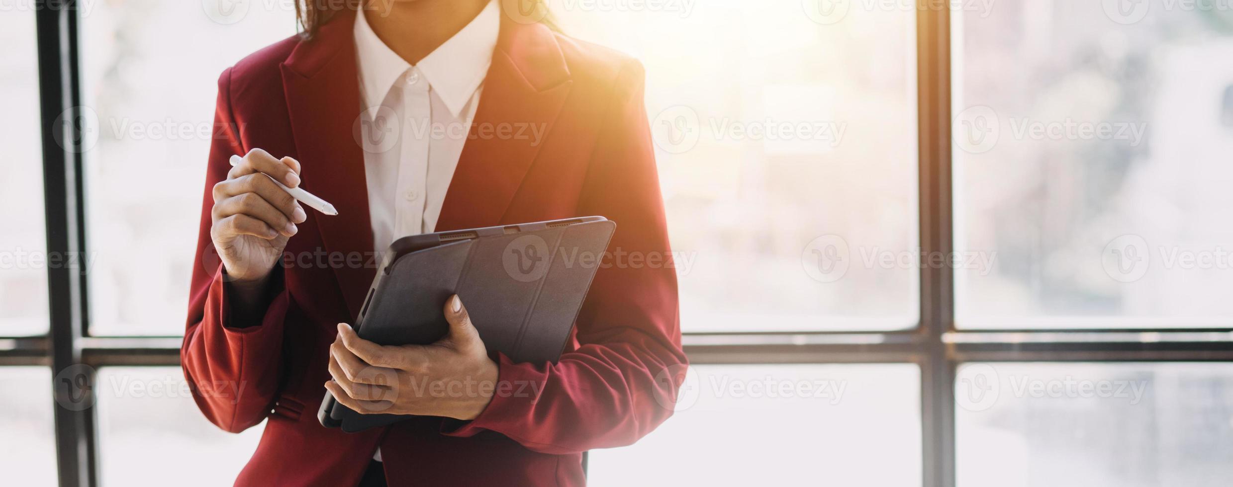 Asian Business woman using calculator and laptop for doing math finance on an office desk, tax, report, accounting, statistics, and analytical research concept photo