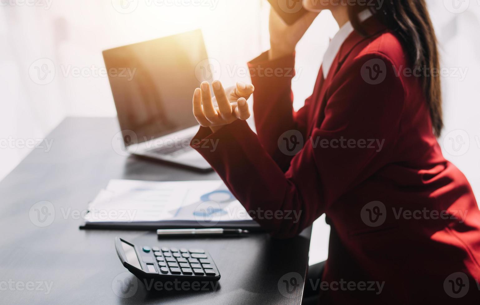 Asian Business woman using calculator and laptop for doing math finance on an office desk, tax, report, accounting, statistics, and analytical research concept photo