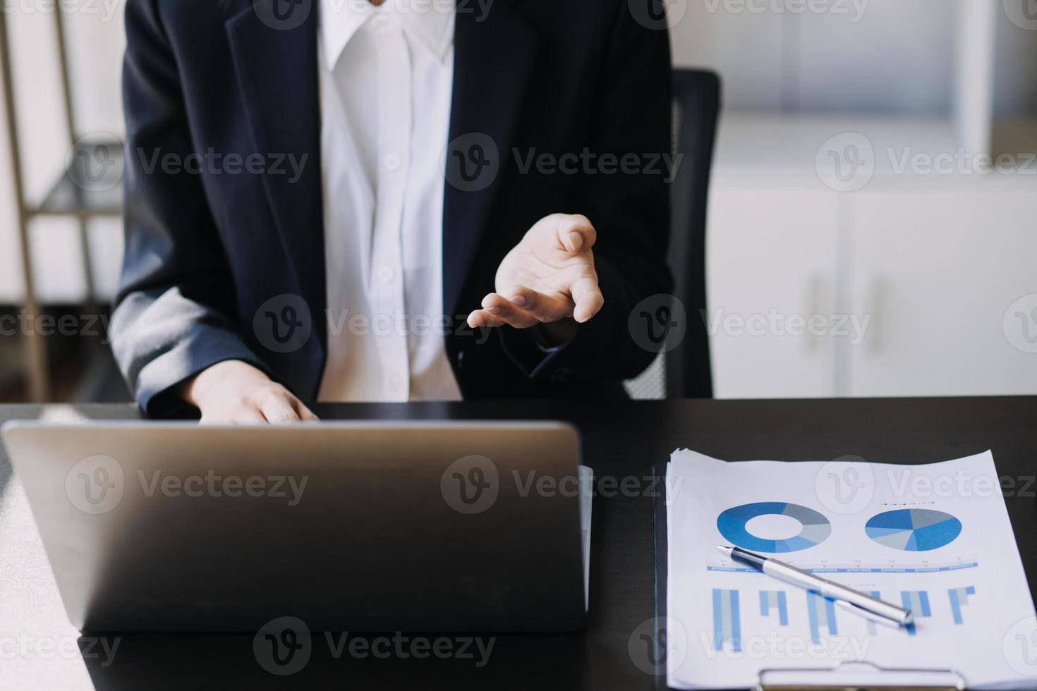 Asian Business woman using calculator and laptop for doing math finance on an office desk, tax, report, accounting, statistics, and analytical research concept photo