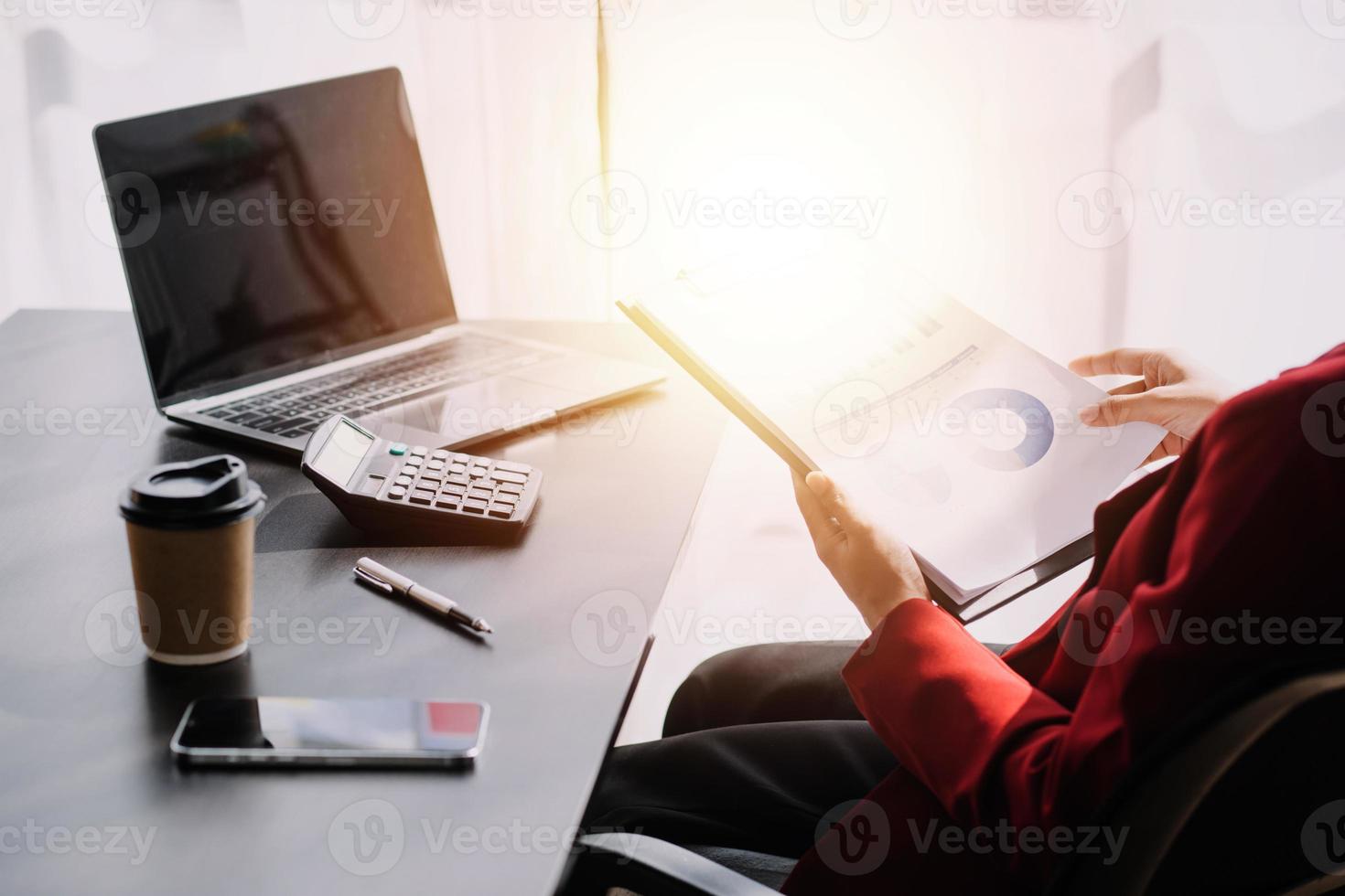 Asian Business woman using calculator and laptop for doing math finance on an office desk, tax, report, accounting, statistics, and analytical research concept photo