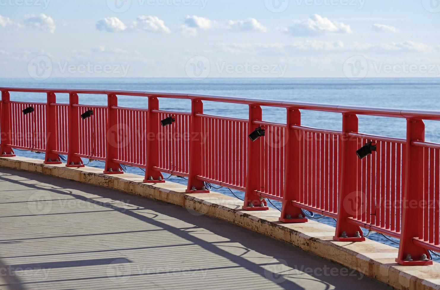 Red fence with the blue sea in the background in Enoshima, Japan photo