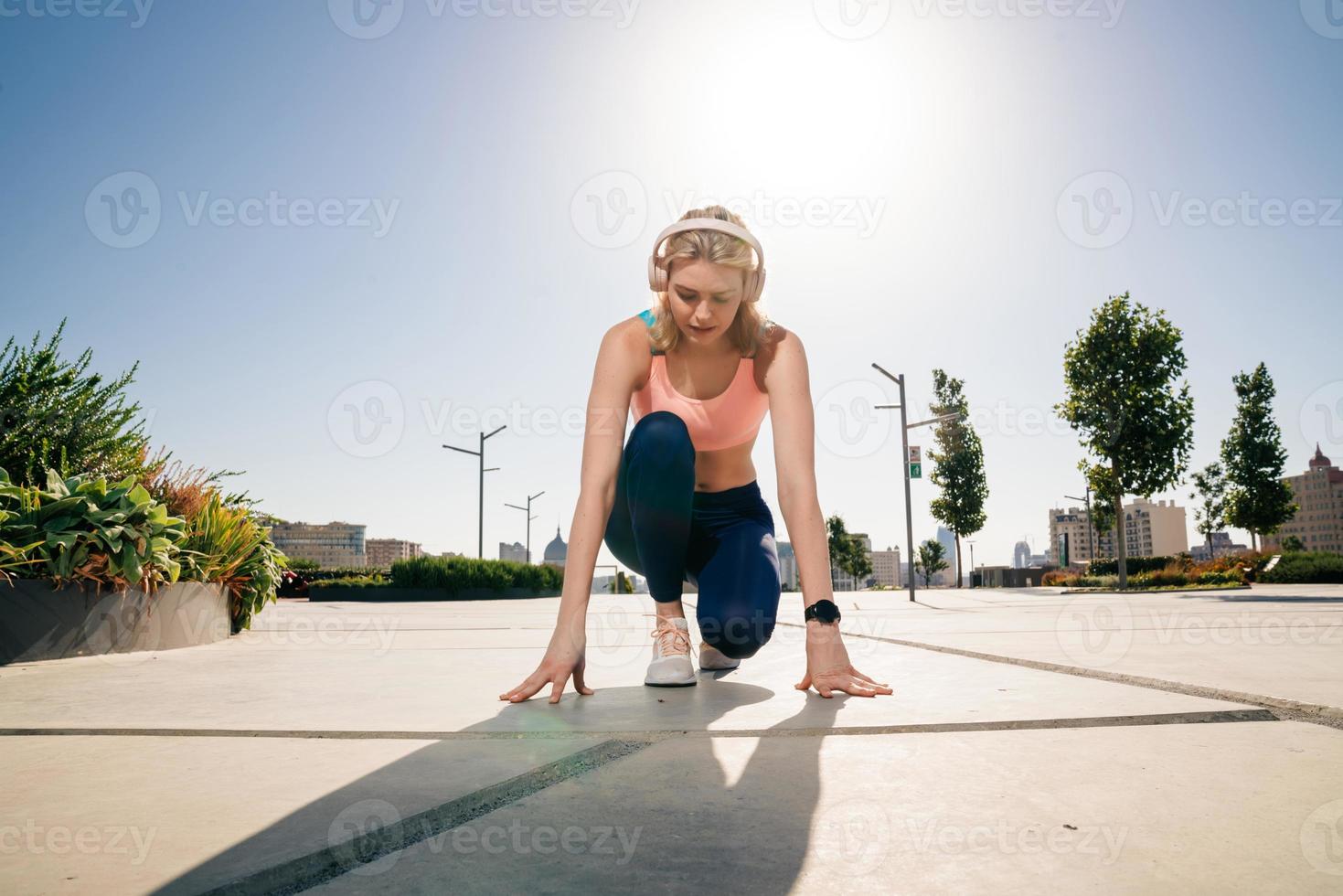 elegant sportive girl wearing headphones prepare to run photo