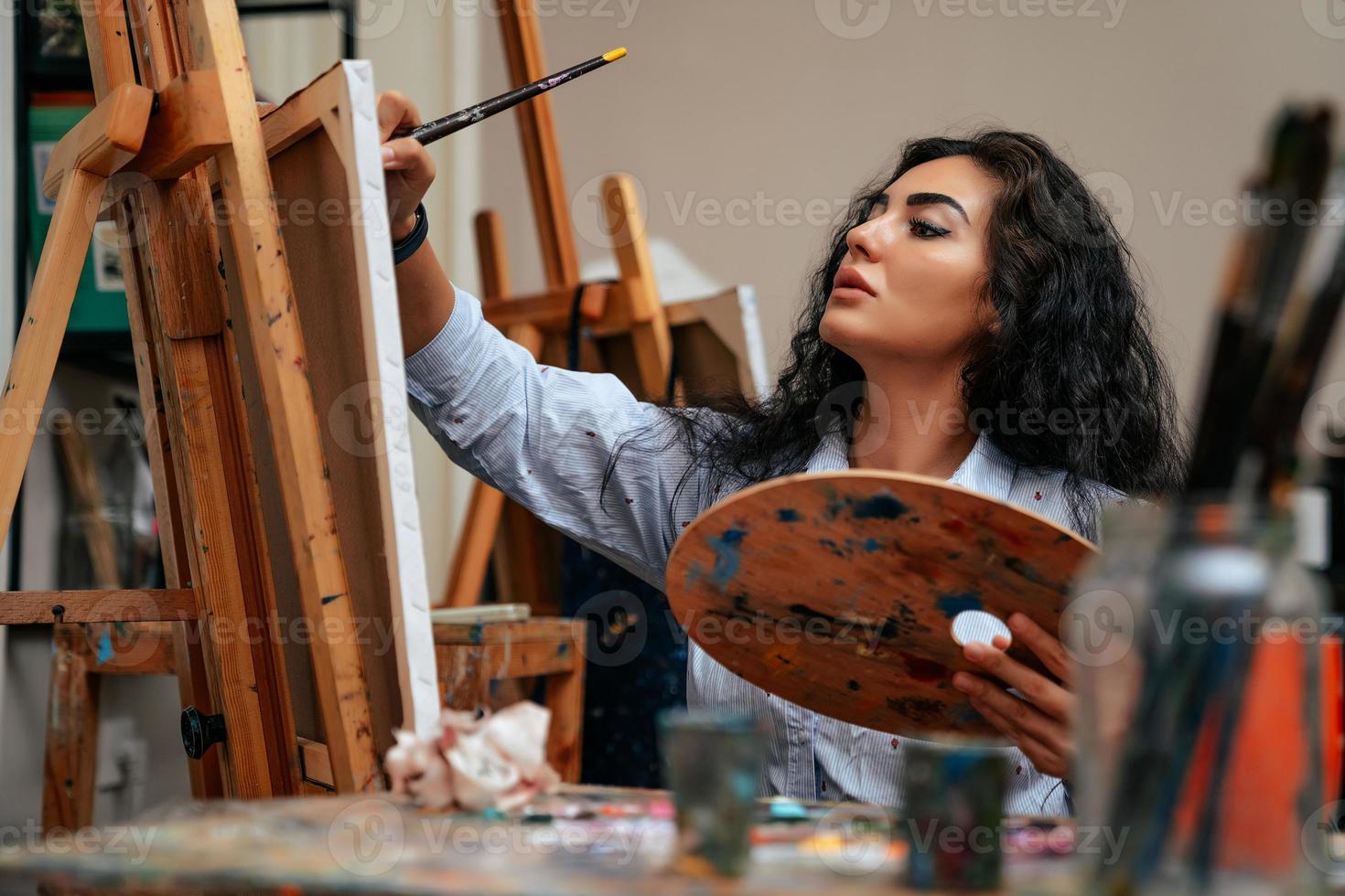 young artist working on a painting at the studio photo