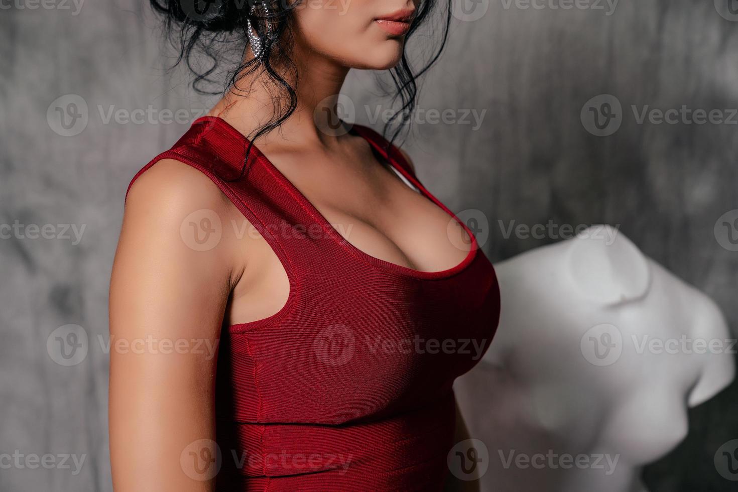 girl in a red evening dress on a gray background photo