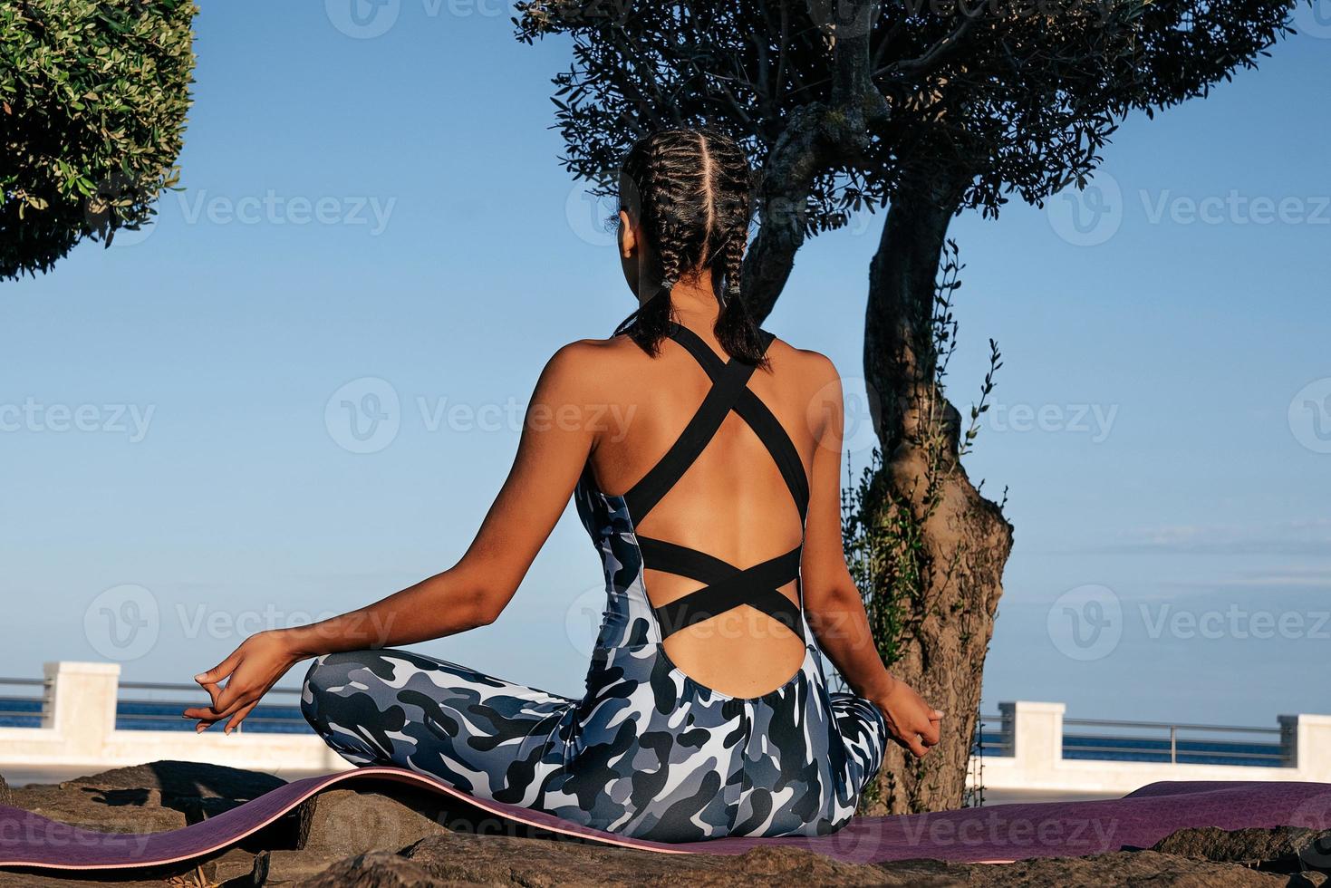 Girl meditates in nature back view photo