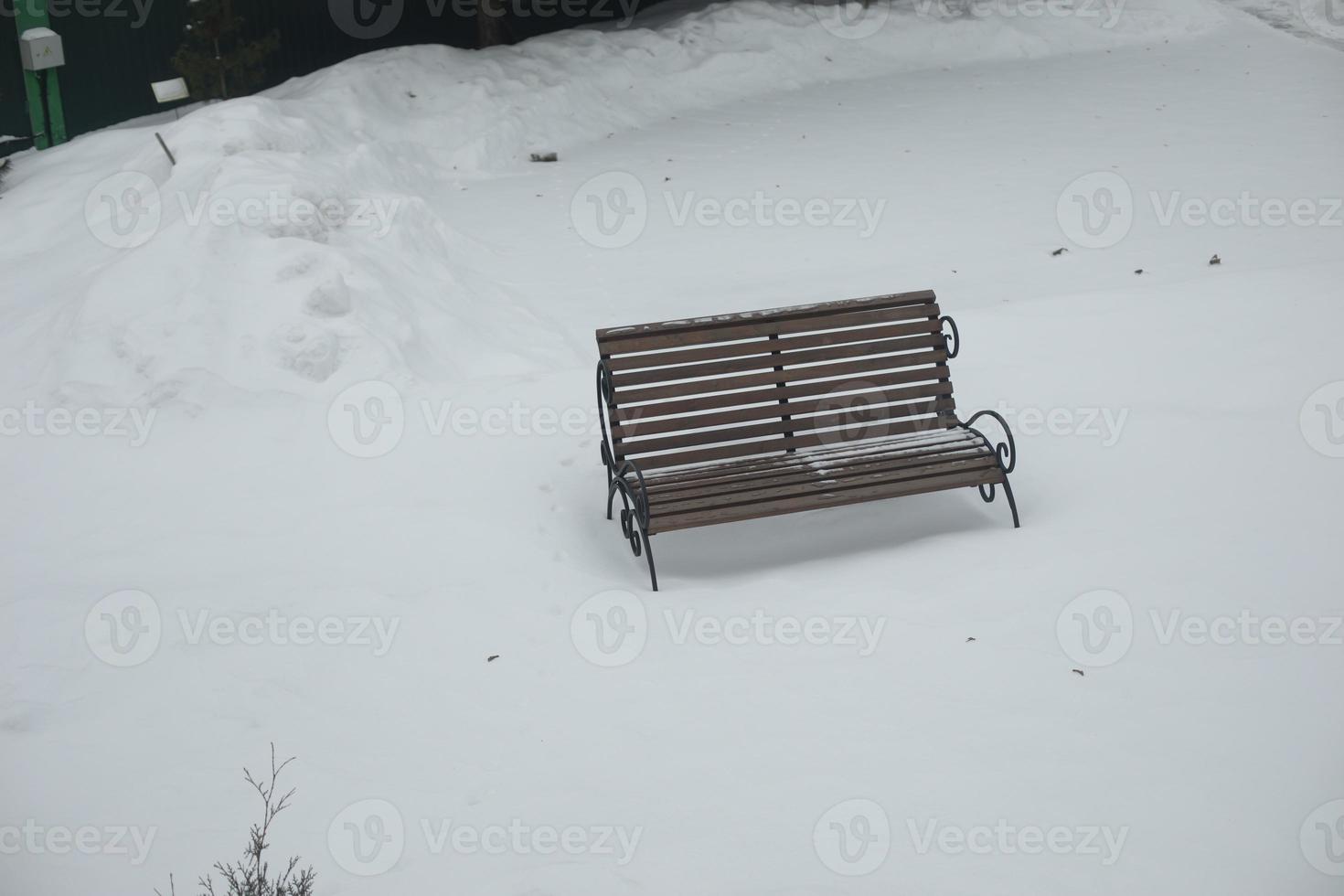 Empty bench in snow. Shop in park. Top view of empty space. photo