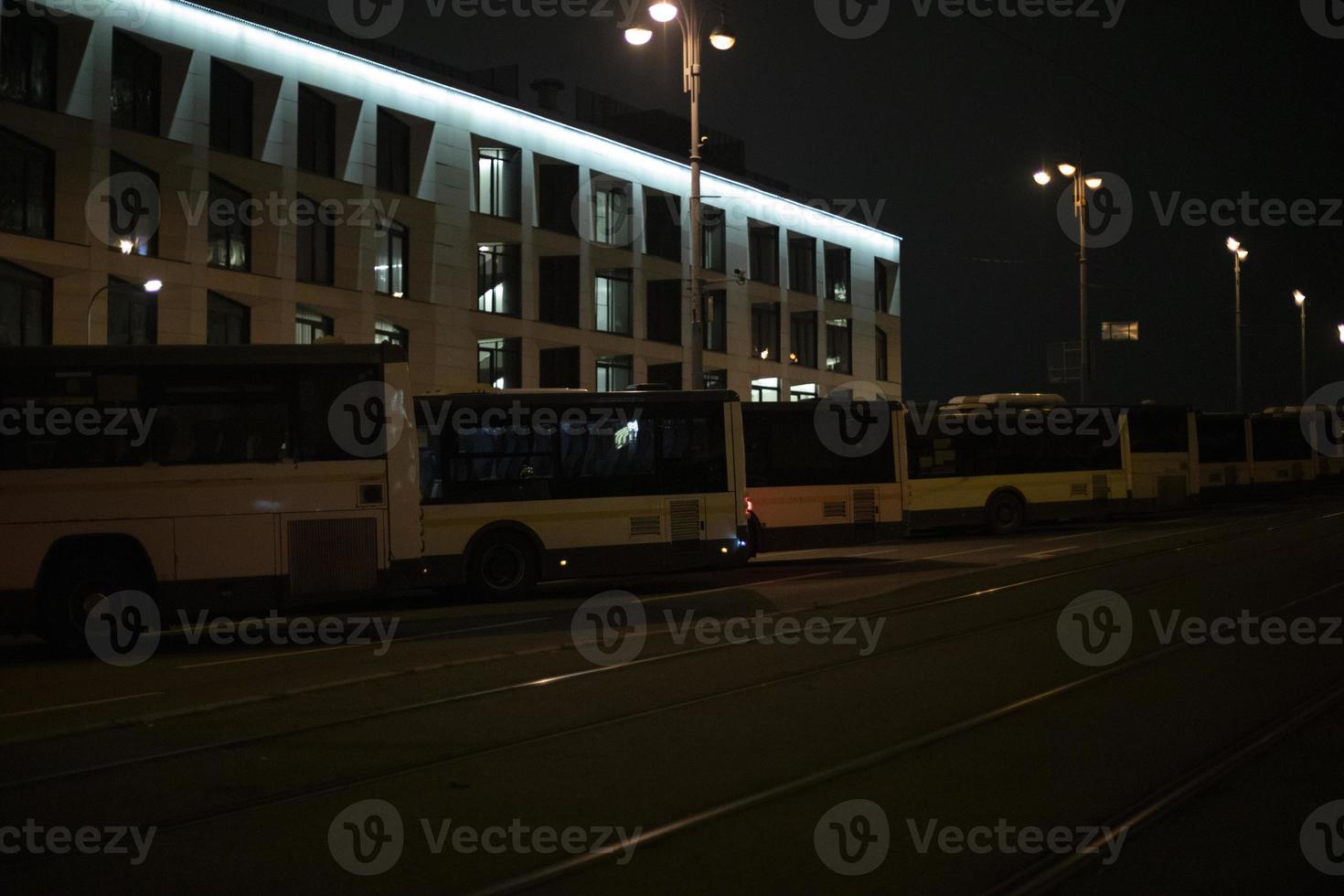 autobuses a noche en estacionamiento lote. ciudad en noche. estacionamiento para público transporte. foto