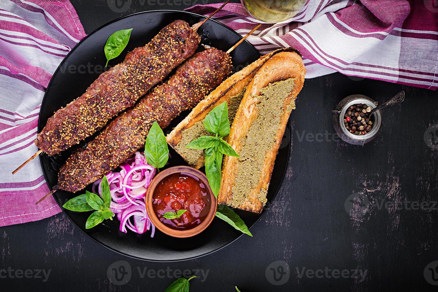 Kebab adana,  lamb and beef and toasts with pesto sauce. Top view photo