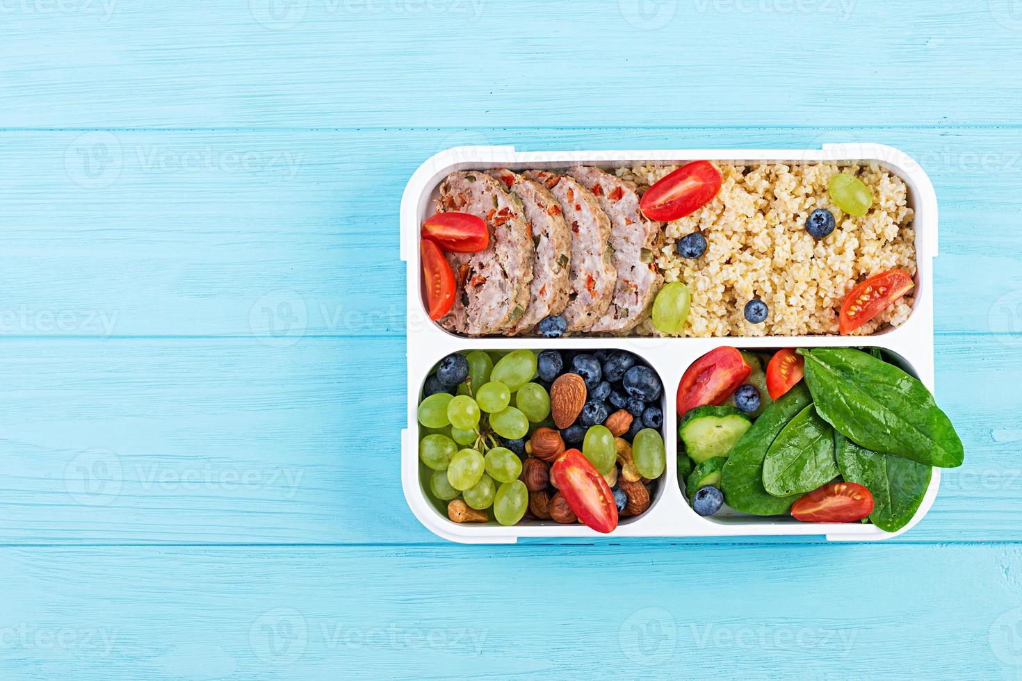 Lunch box  meatloaf, bulgur, nuts, tomato  and berry. Healthy fitness food. Take away. Lunchbox. Top view photo