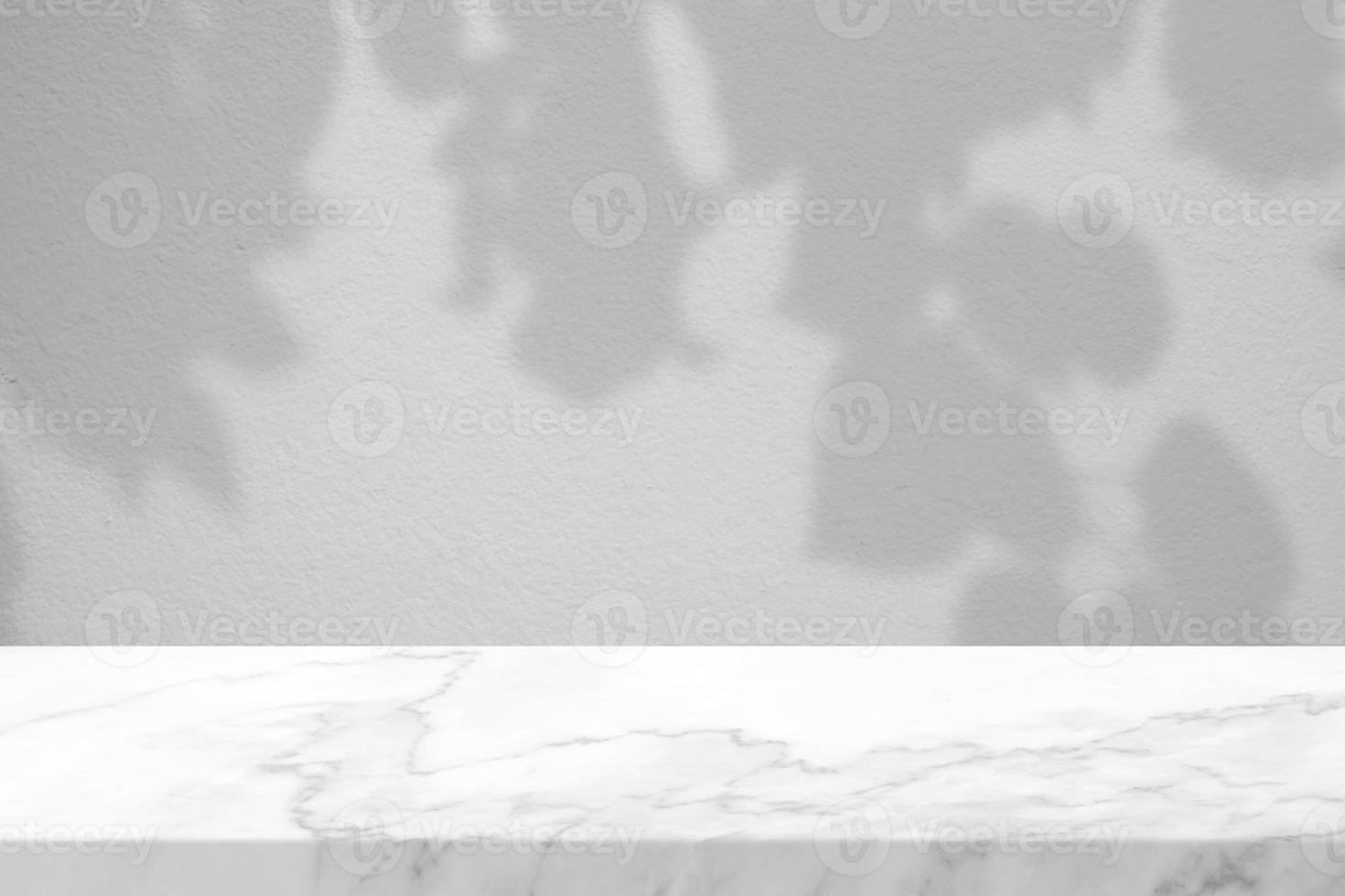 White Marble Table with Tree Branches Shadow on Grey Concrete Wall Texture Background, Suitable for Product Presentation Backdrop, Display, and Mock up. photo