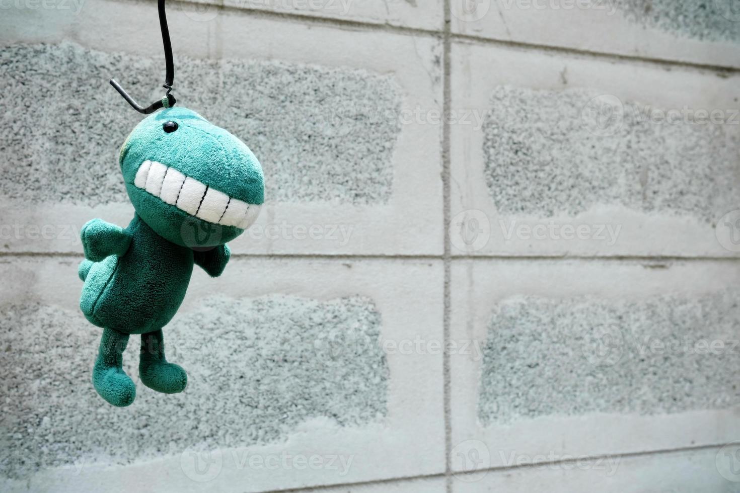 Left Dinosaur Doll Hanging on the Wall. photo