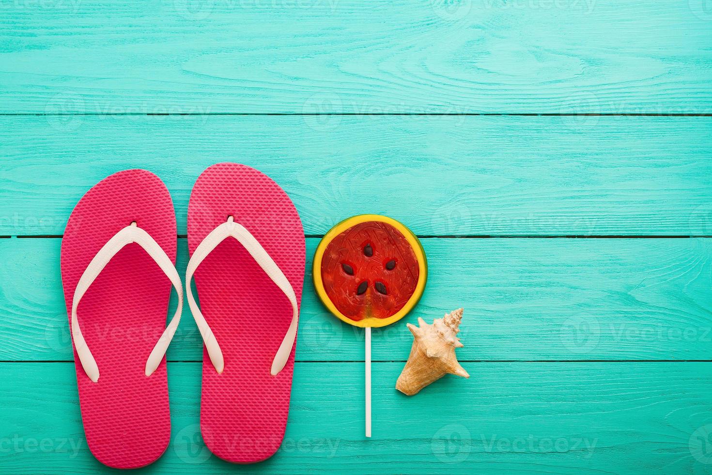 Summer accessories. Flip flops, sunglasses, towel, red cap and oranges on blue wooden background. copy space. photo