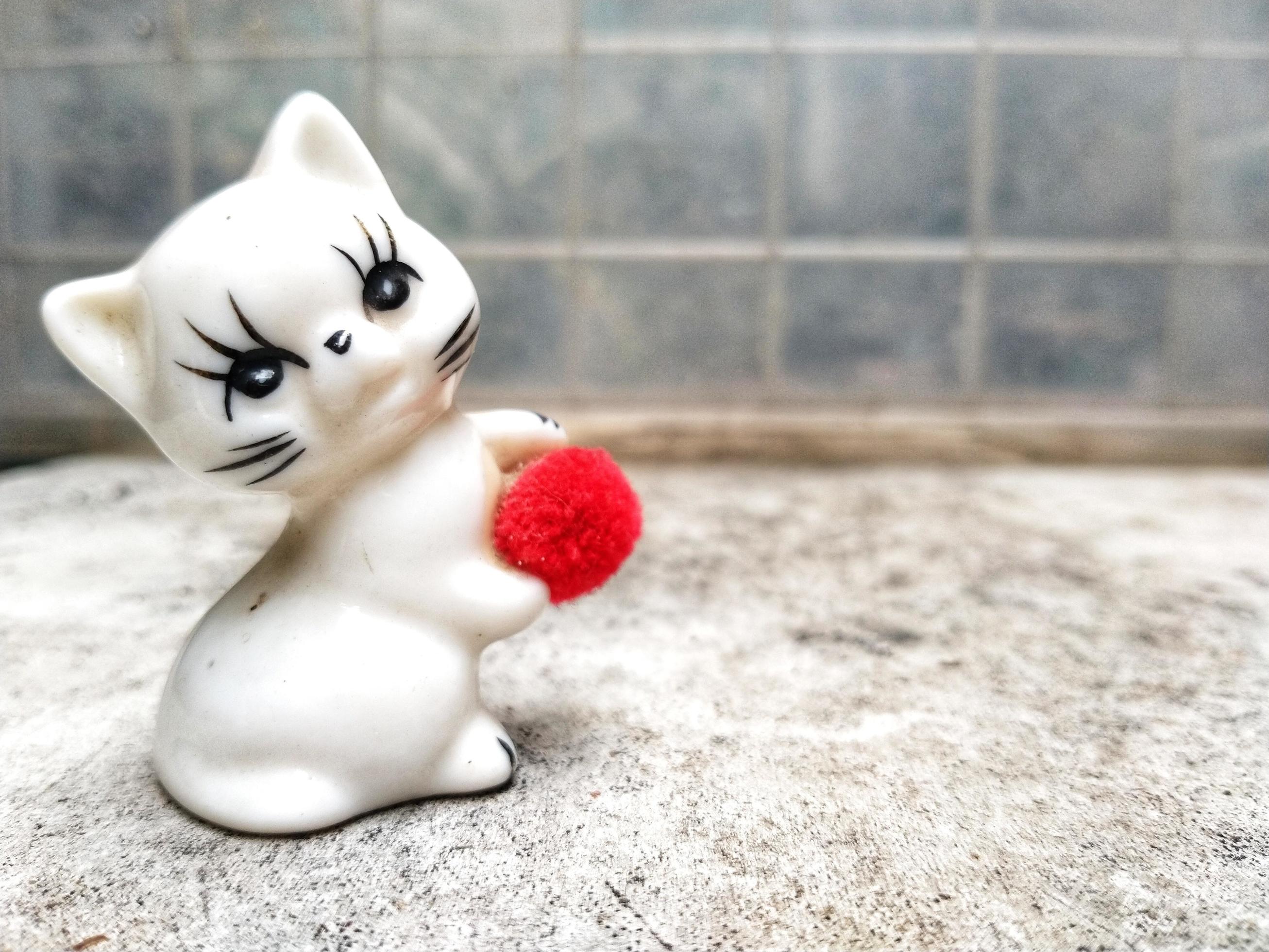 Neko figurine, ceramic cats sculpture place on outdoor with abstract