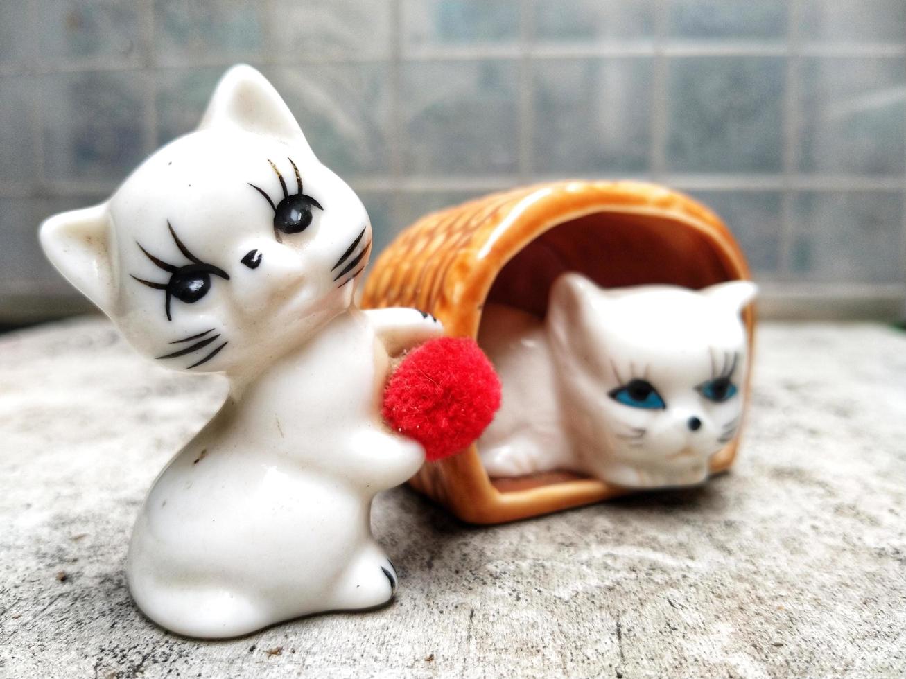 Neko figurine, ceramic cats sculpture place on outdoor with abstract background photo