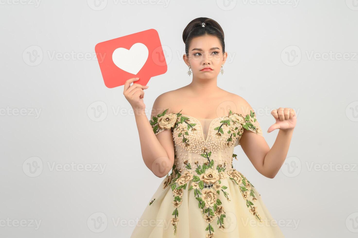 Asian beautiful bride smiling and posing with heart sign on white background photo