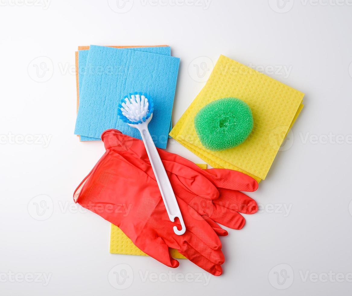 items for home cleaning red rubber gloves, brush, multi-colored sponges for dusting photo