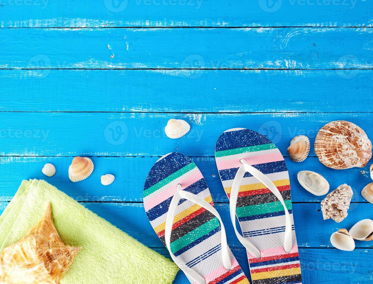 pair of female beach slippers and a green towel photo