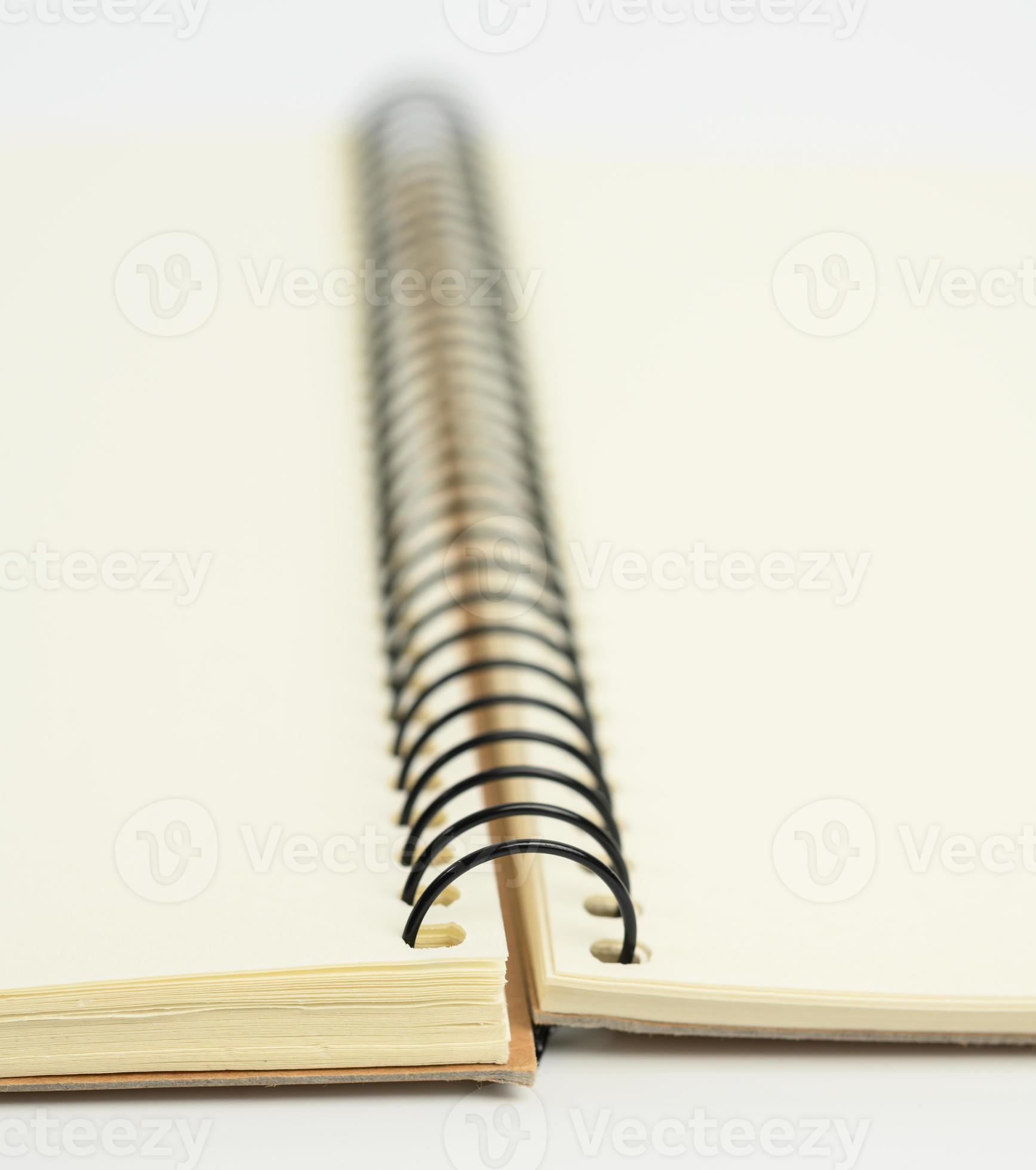 Blank white spiral notebook containing book, notebook, and white