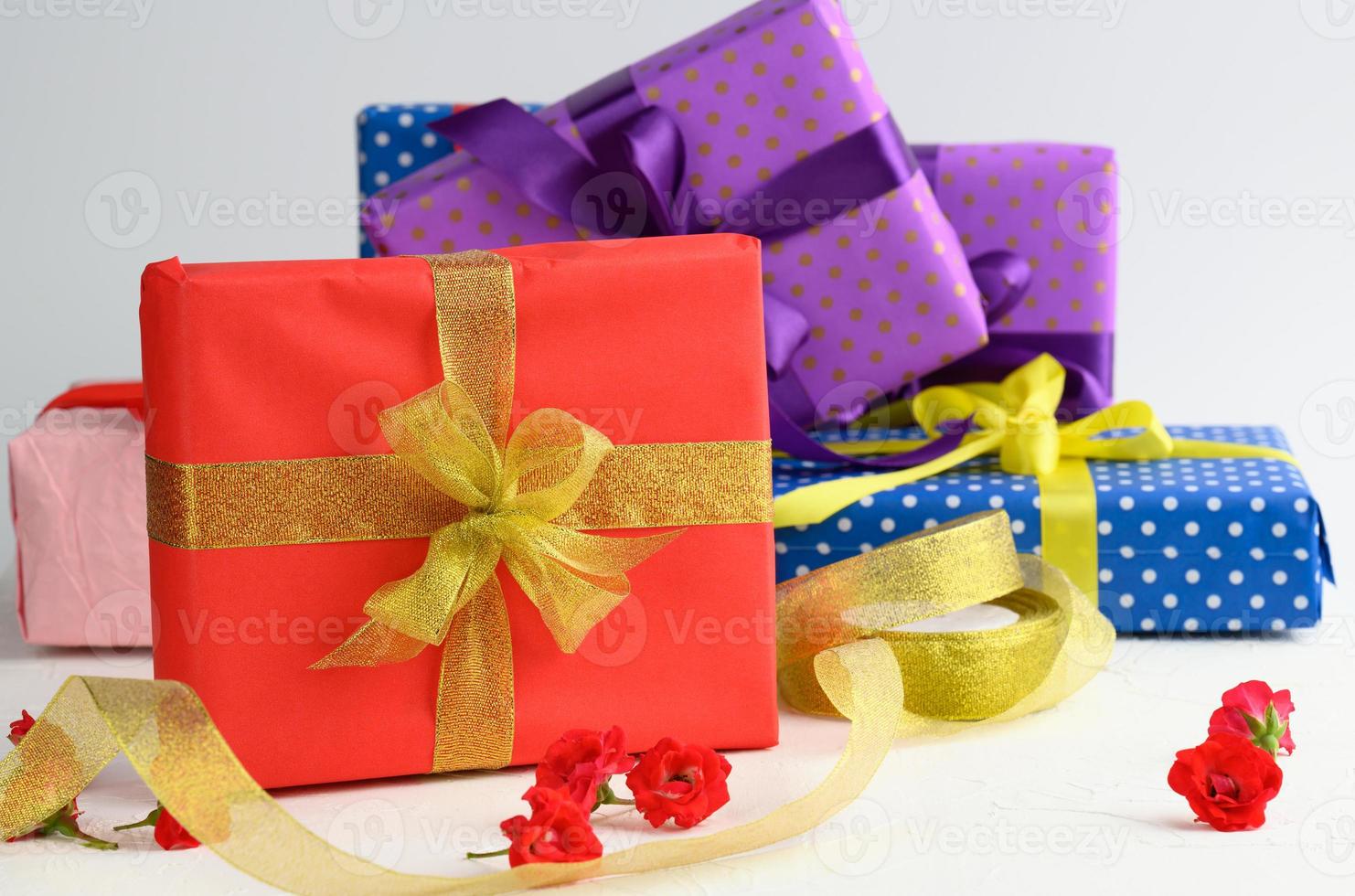 boxes packed in festive paper and tied with silk ribbon on a white background, birthday gift photo