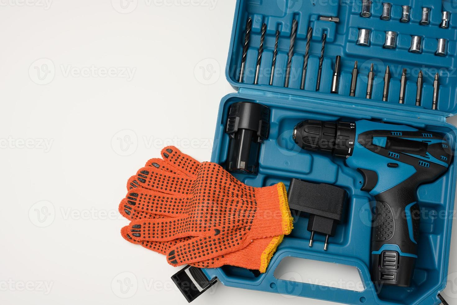 plastic box with cordless drill and set of drills and screwdrivers on white background photo