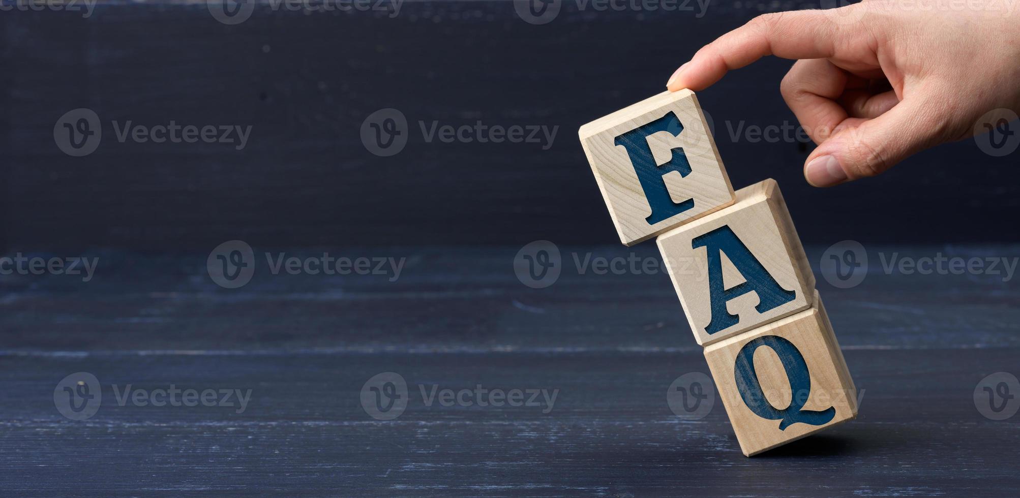 inscription FAQ frequently asked questions on wooden blocks on a blue background photo