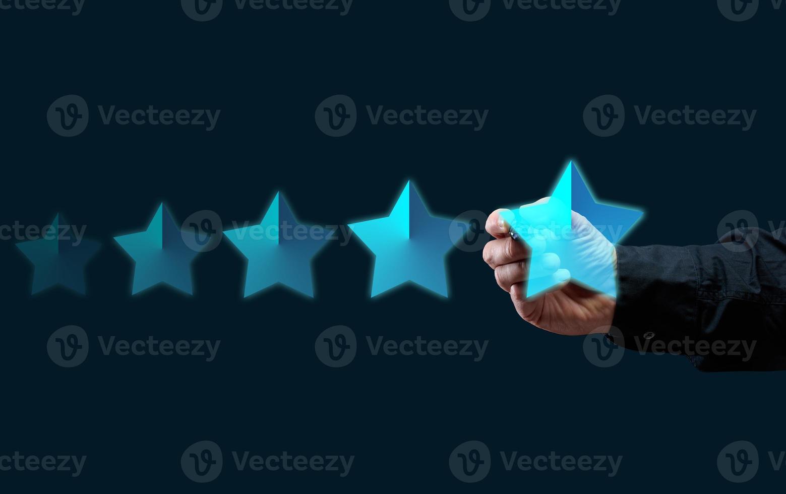 five holographic stars and a man's hand on a dark blue background. Business evaluation concept by users, rating and voting photo