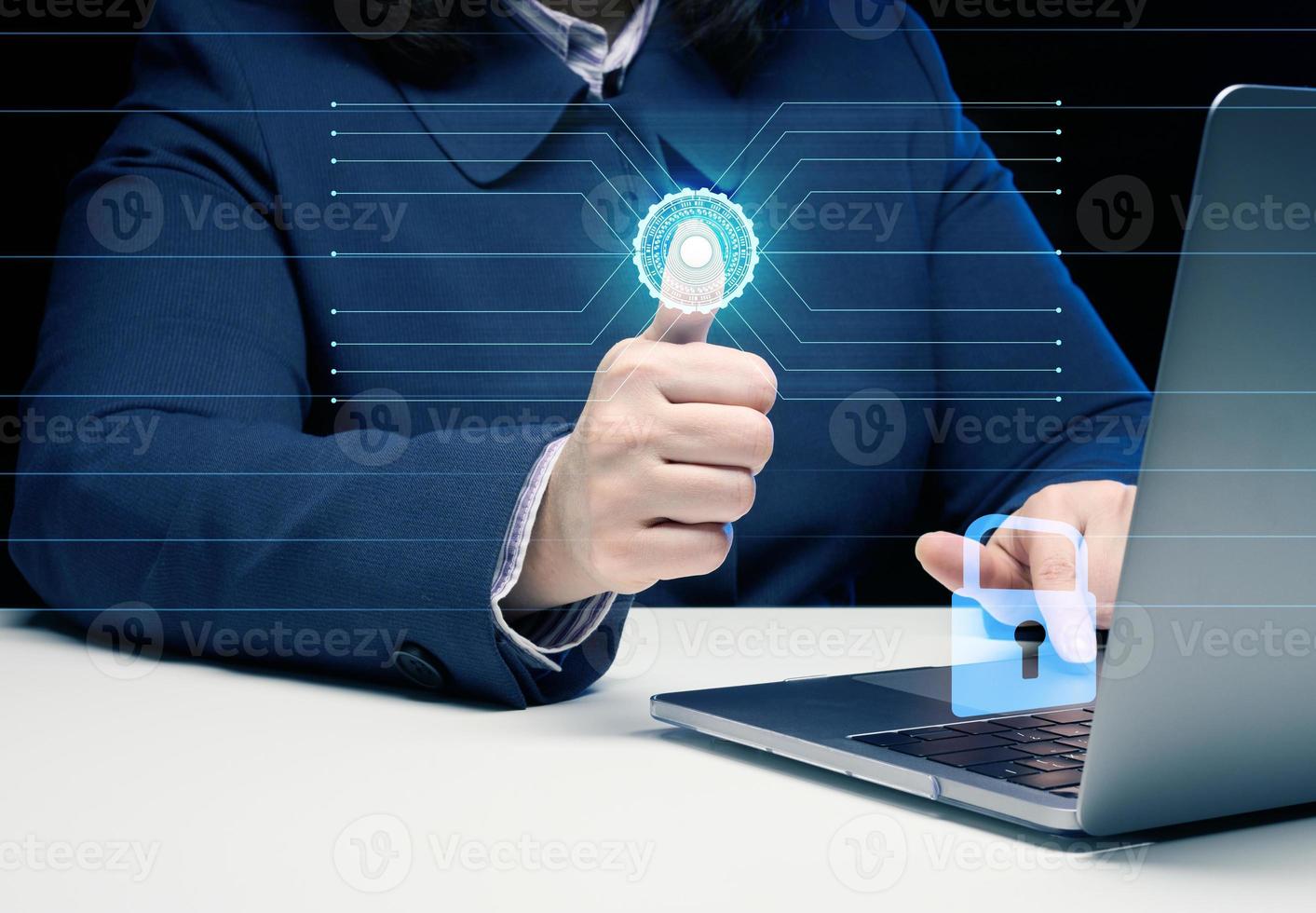 a woman sits at a table and works at a laptop. The hand presses a virtual button to scan the fingerprint. The concept of personal data protection photo