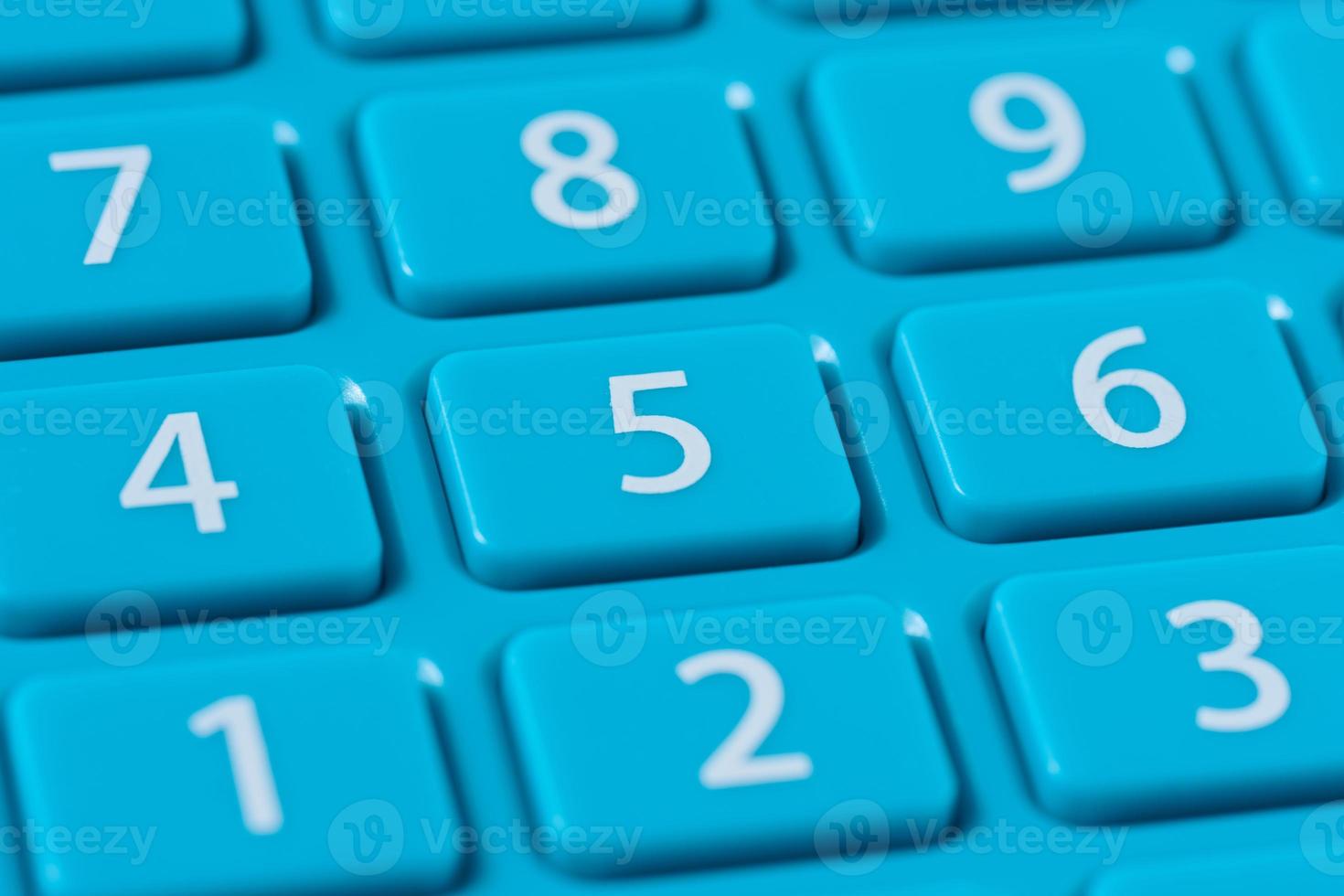 Button with numbers on a blue plastic calculator, keyboard photo