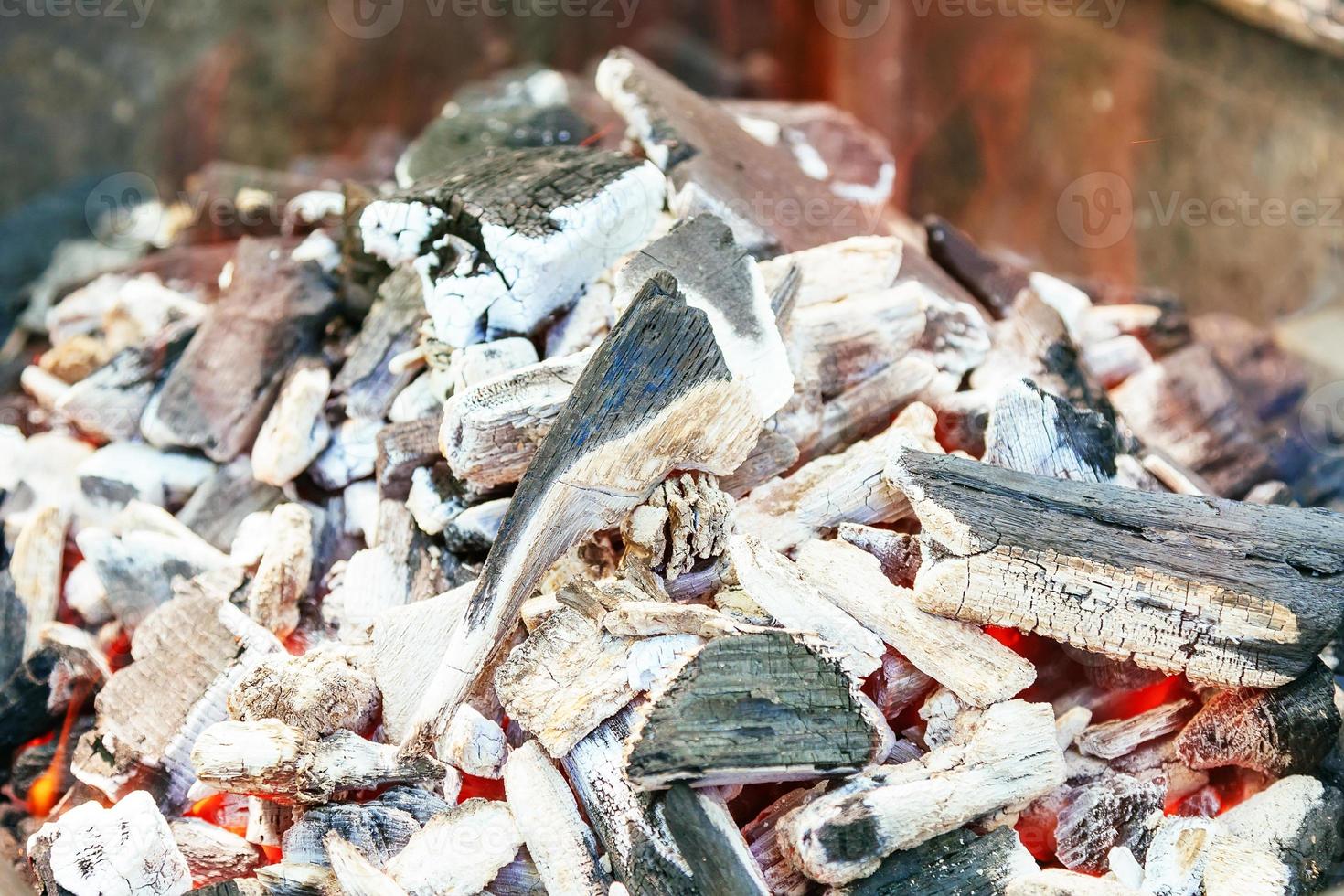 Burning charcoal with orange-colored flame and glow Selective Focus, on parts of the pieces around the photo