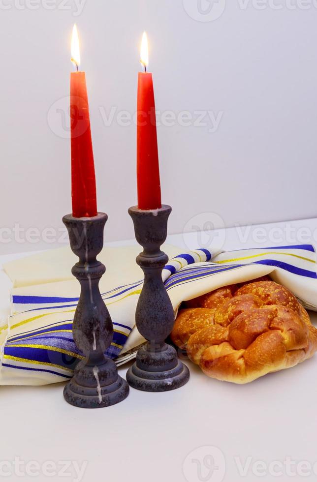 mesa conjunto para Shabat con iluminado velas, jalá un pan y vino. foto