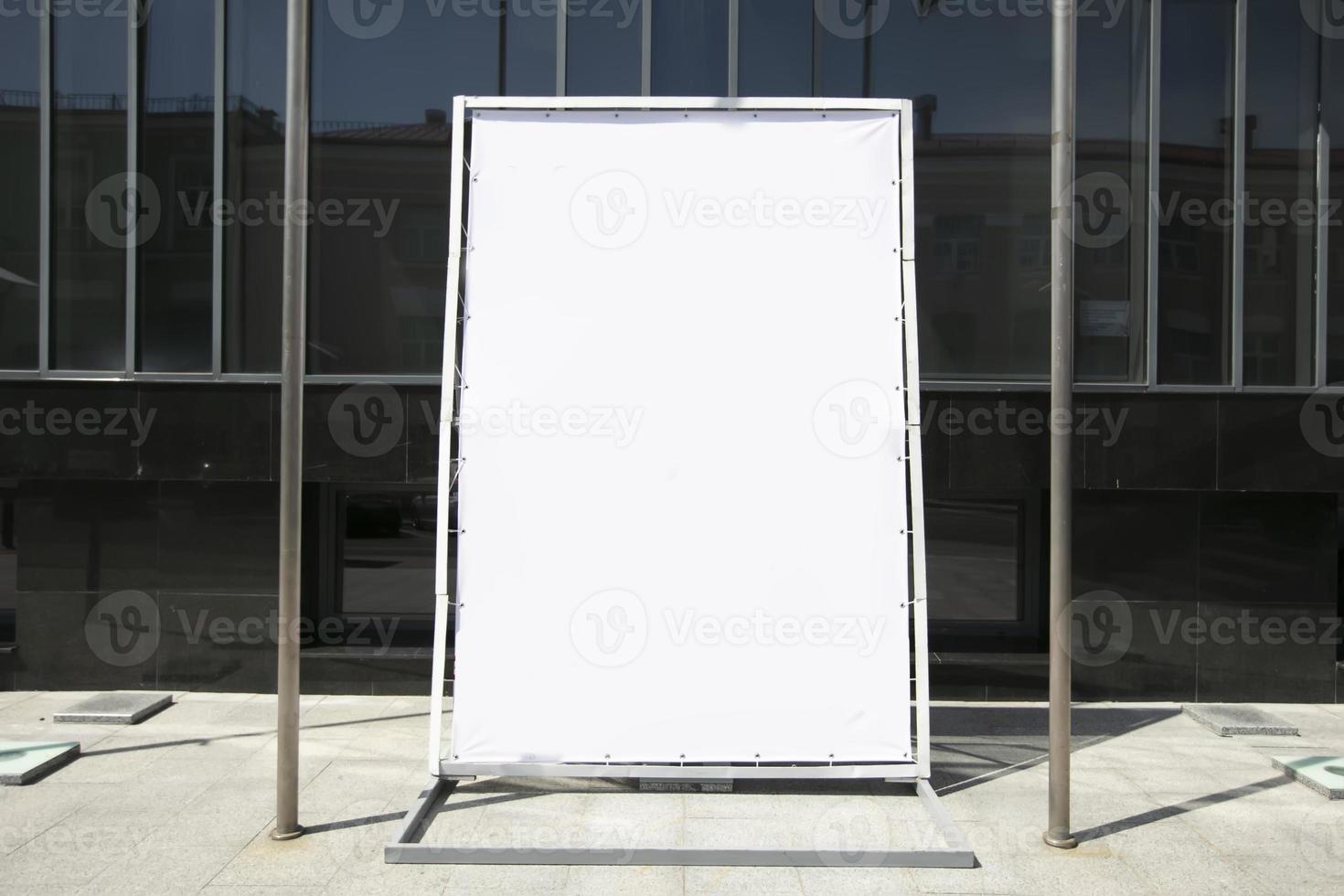 An empty advertising banner stands on a city street. photo