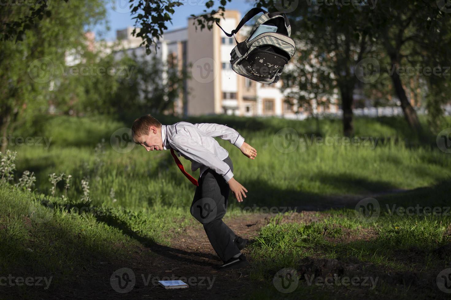 A happy schoolboy throws up his school backpack and rejoices at the start  of the holidays. The end of the school year and the beginning of the  holidays. 19825456 Stock Photo at