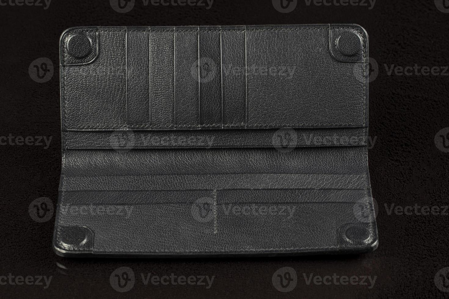 Black leather wallet on a black background. photo