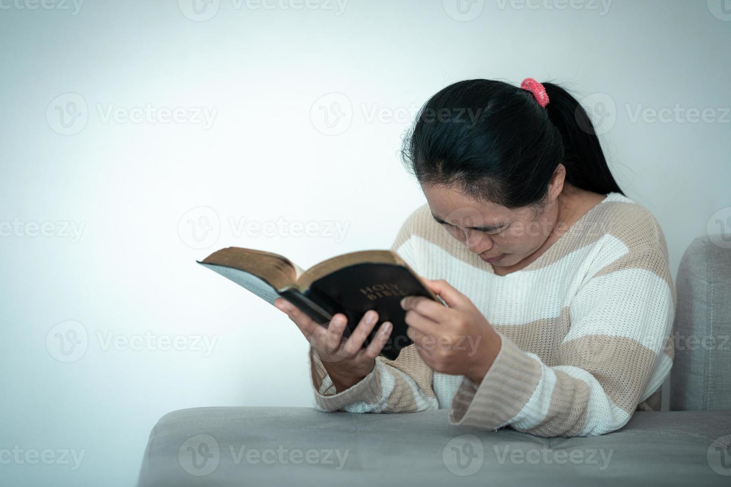 woman kneeling and praying in modern house at sunset time. Female catholic prayer worship to God wish a better life in home at dawn with believe faith. concept of worshipers kneeling. photo