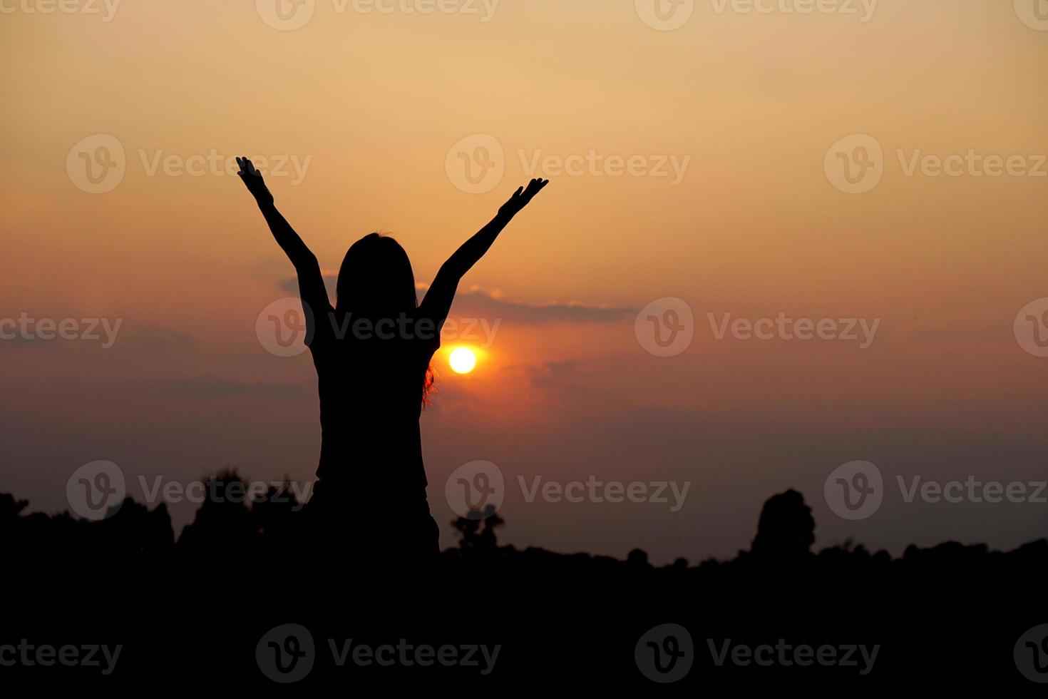 silhouette of human hand raised to make a wish, sunset background photo