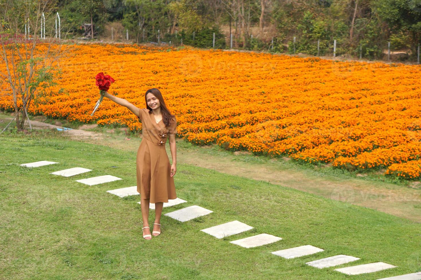 Asian woman smiling happily among beautiful flowers photo