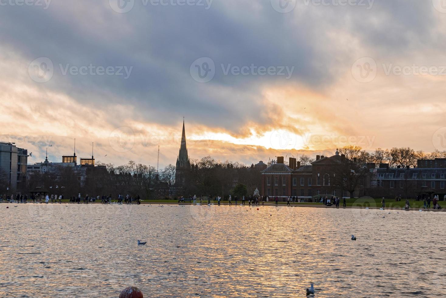 Beautiful lake with St Mary Abbots church and Kensington Palace during sunset photo