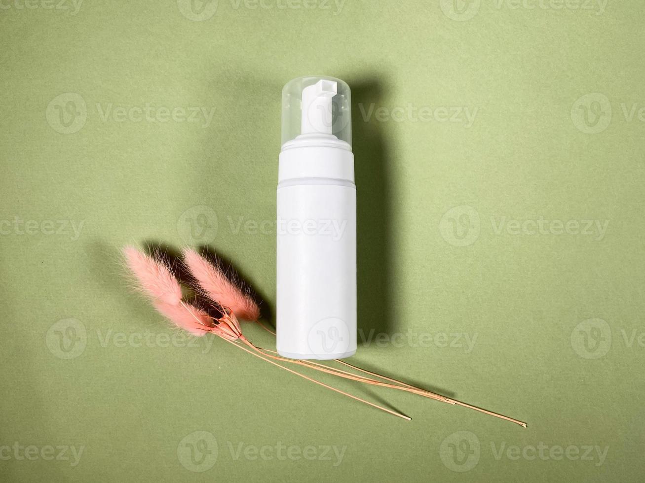 closed white blank plastic bottle lies on khaki photo