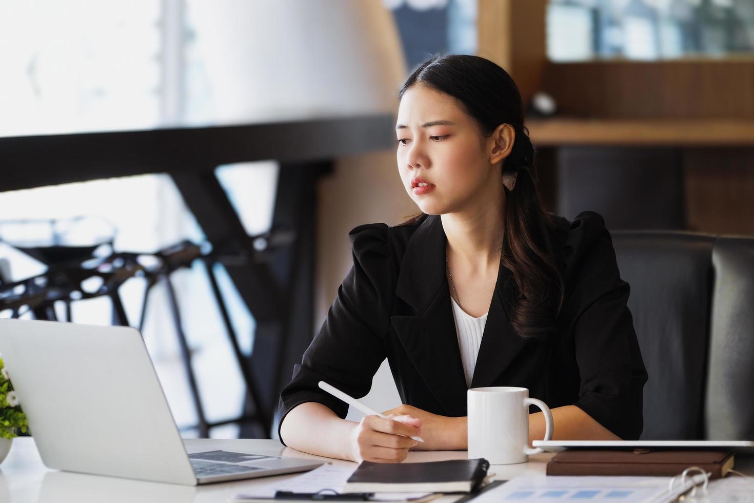 los empleados de la empresa muestran aburrimiento por el trabajo inconcluso usando computadoras portátiles, documentos y tabletas en el trabajo. foto