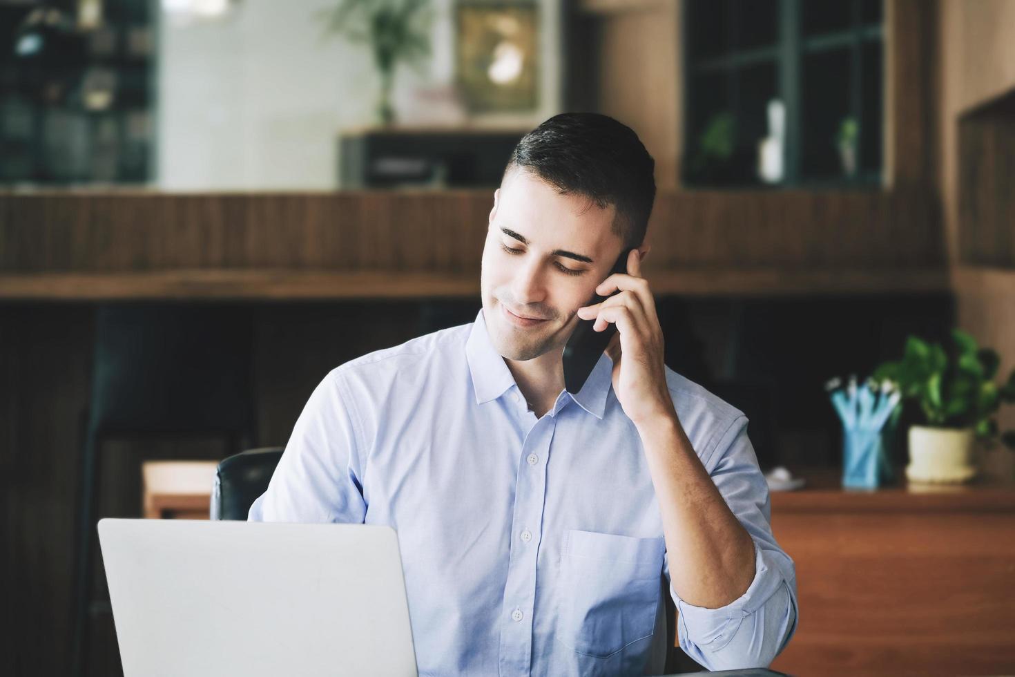 gerente de marketing masculino que usa el teléfono para hablar con una empresa de capital de riesgo para aumentar el potencial de ganancias. foto