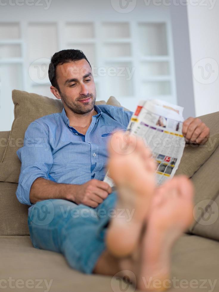 young man relaxing and dreaming on sofa at home photo