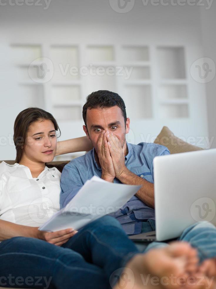 relaxed young couple working on laptop computer at home photo