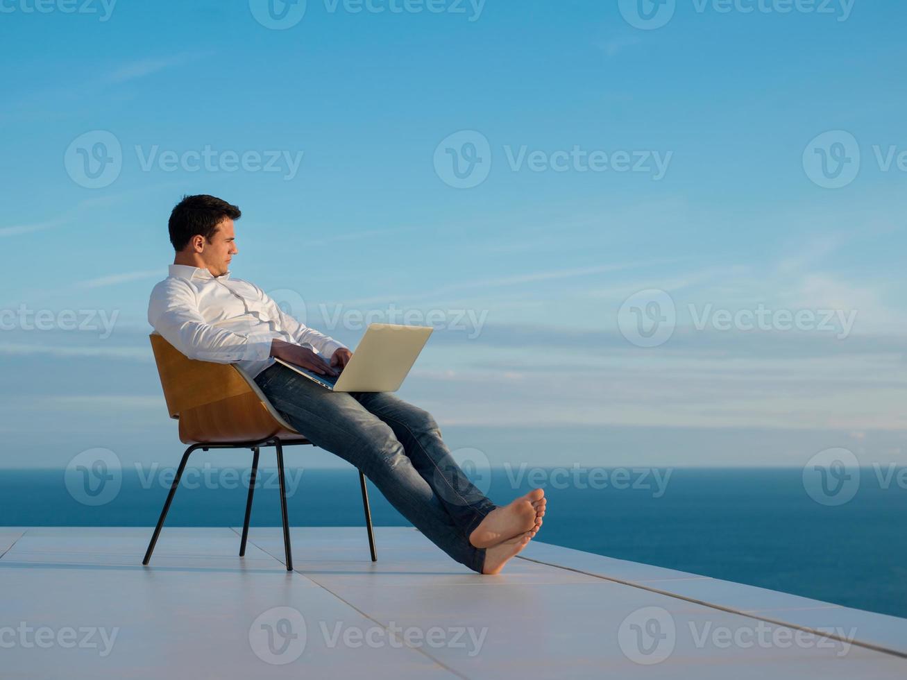 relaxed young man at home on balcony photo