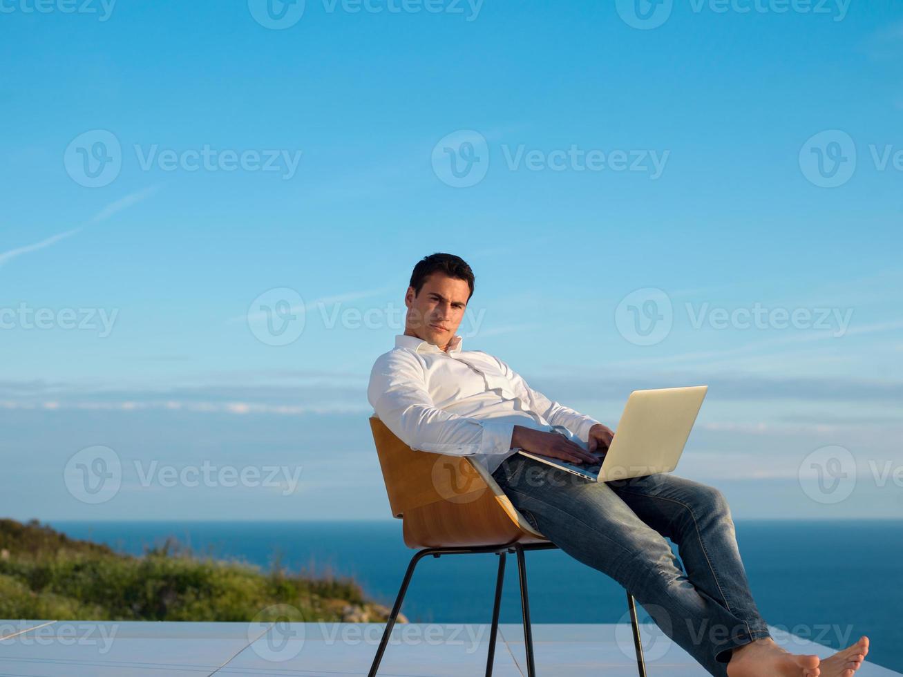 relaxed young man at home on balcony photo
