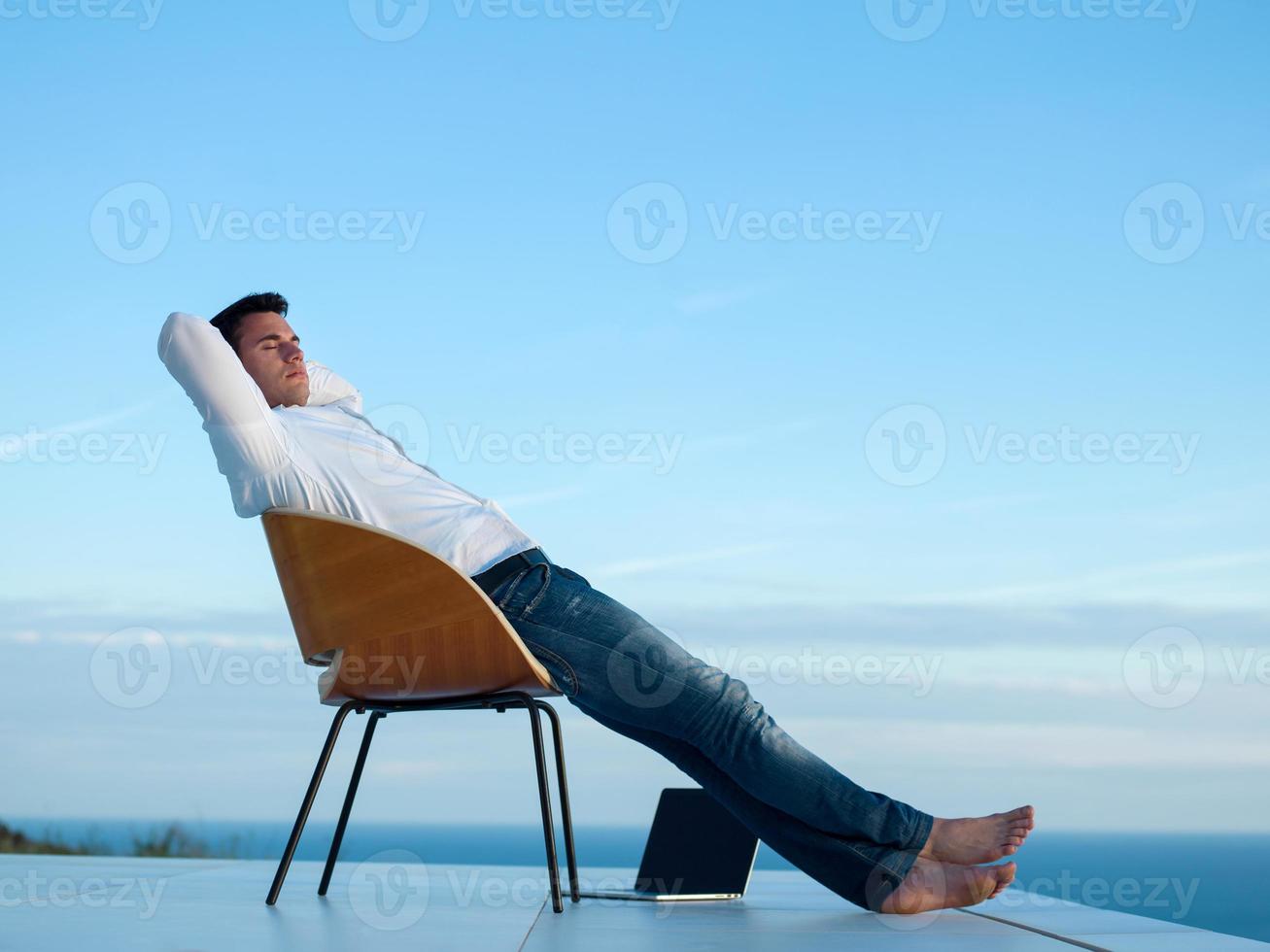 relaxed young man at home on balcony photo